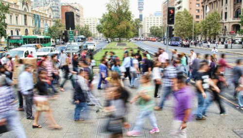 Cityscape with crowds of people walking around.