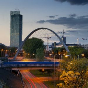 Photo of city landscape with bridge over road, highrise building in background