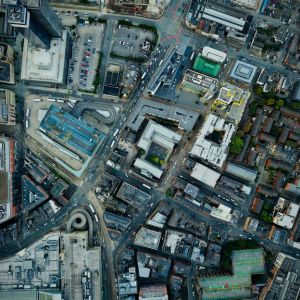 Aerial view of a city, of buildings and small patches of trees.